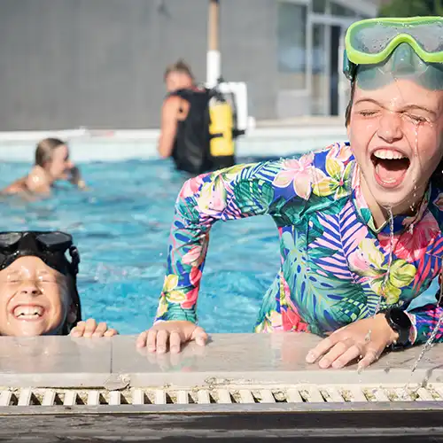 Zwei Mädchen plantschen im Swimmingpool
